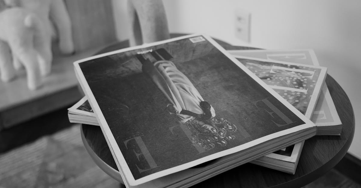 Monochrome image of fashion magazines on a table in a stylish interior setting.